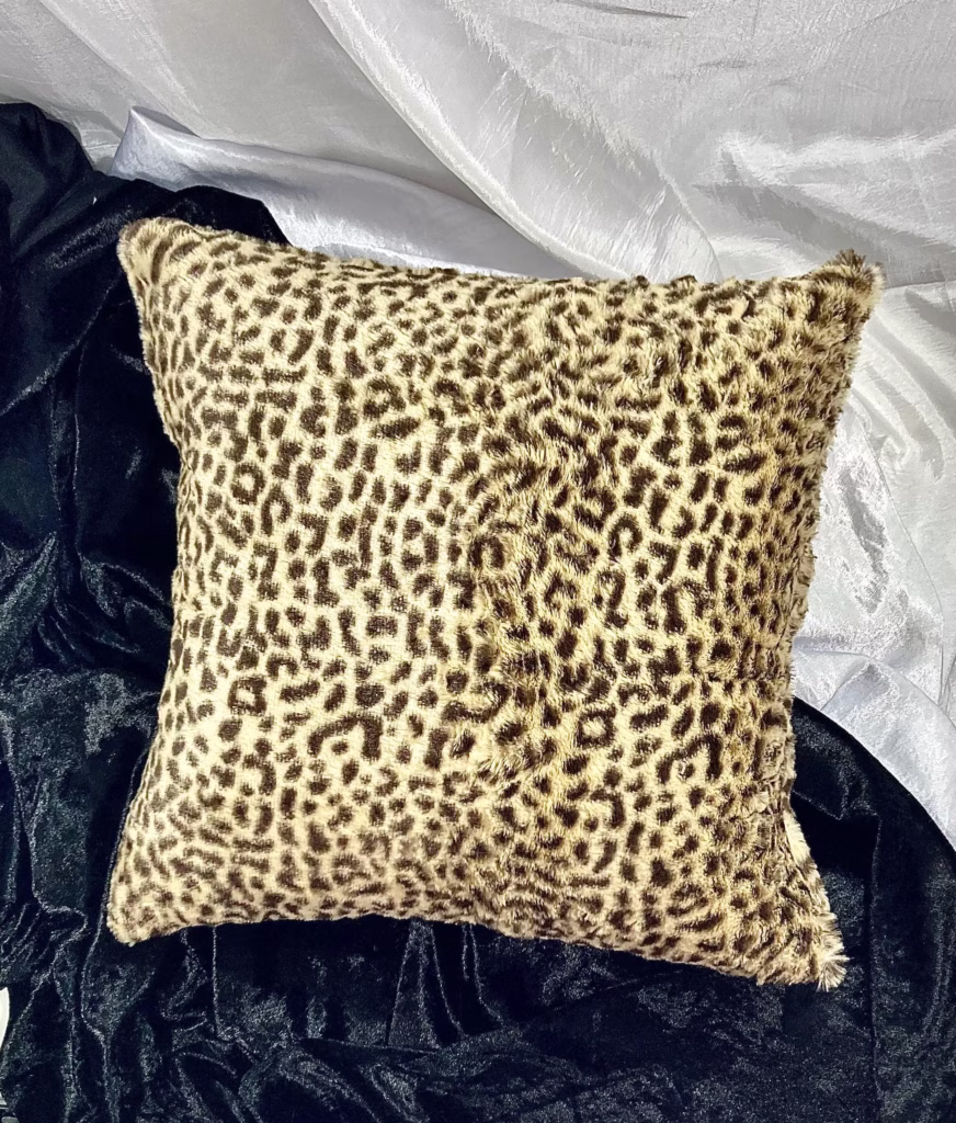 Cheetah pillow black and white background Cheetah faux fur luxury decorative pillow against black fur and white satin background